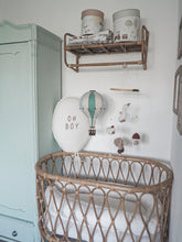 Load image into Gallery viewer, Nursery with wicker crib, decorative balloons, and shelves.