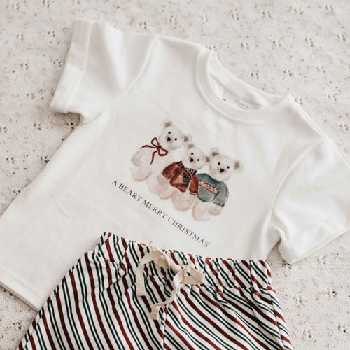 White t-shirt with Christmas design and striped shorts on a light background