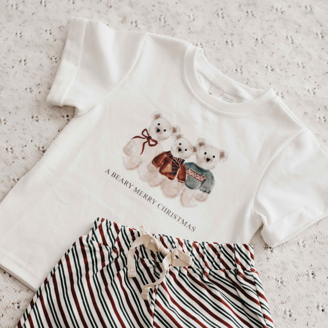 White t-shirt with Christmas design and striped shorts on a light background