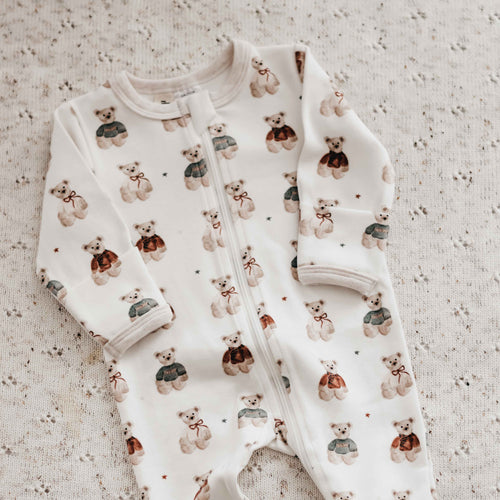 Baby outfit with teddy bear pattern on a textured surface
