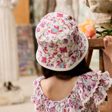 將圖片載入圖庫檢視器 Child wearing a floral dress and hat in an indoor setting with decorative elements.
