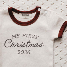 Load image into Gallery viewer, A baby bodysuit with 'MY FIRST Christmas 2026' printed on the front, featuring a cream body and dark red trim, laid flat on a textured cream fabric background.
