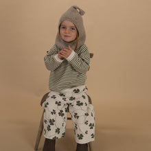 Load image into Gallery viewer, Child wearing a striped shirt, patterned pants, and a hooded outfit on a beige background

