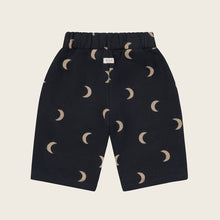 Load image into Gallery viewer, Black shorts with beige crescent moon pattern on a beige background
