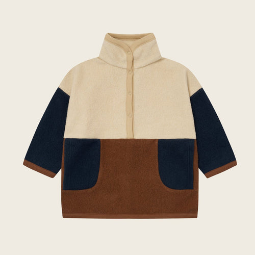 Color-blocked sweater with beige, navy, and brown sections on a light beige background