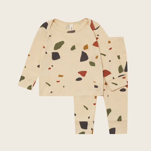 Children's pajama set with colorful abstract pattern on a beige background